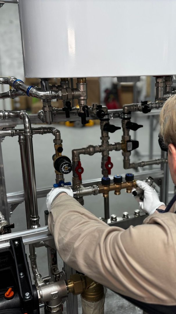 Techniker prüft und justiert professionell ein Rohr- und Ventilsystem mit hochwertigem Werkzeug