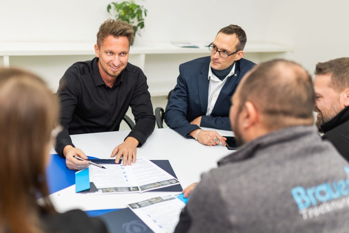 Partner und Brauer-Team diskutieren lachend am Besprechungstisch