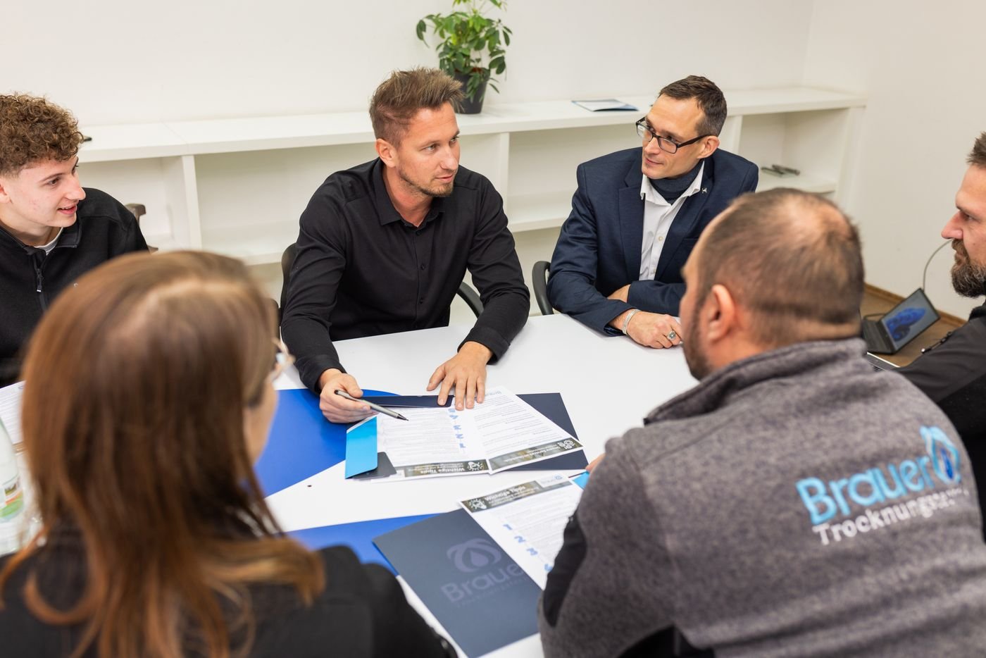 Friedrich Brauer im Gespräch mit Partnern am Besprechungstisch