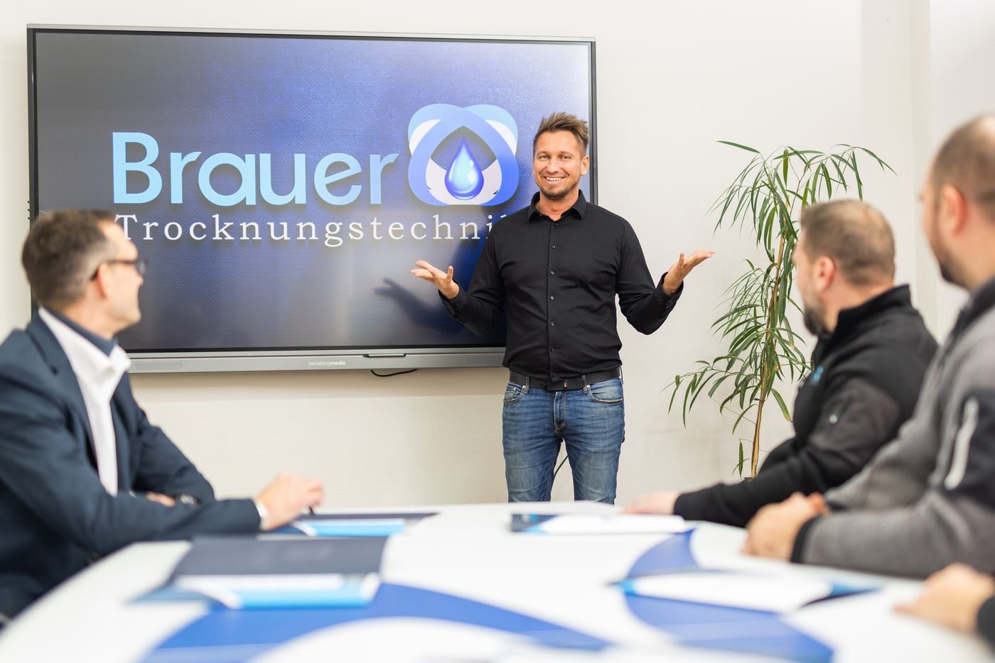 Friedrich Brauer präsentiert vor dem Team im Besprechungsraum